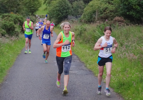 Photo of a group of runners tackling a hill during a race.