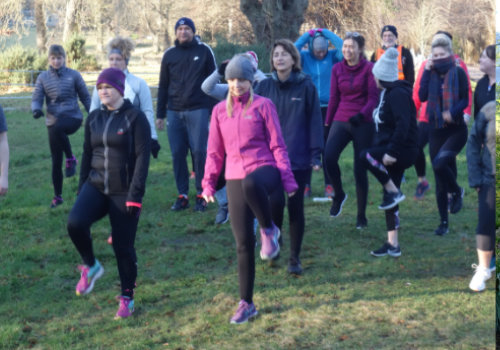 photo of a group of runners standing on one leg