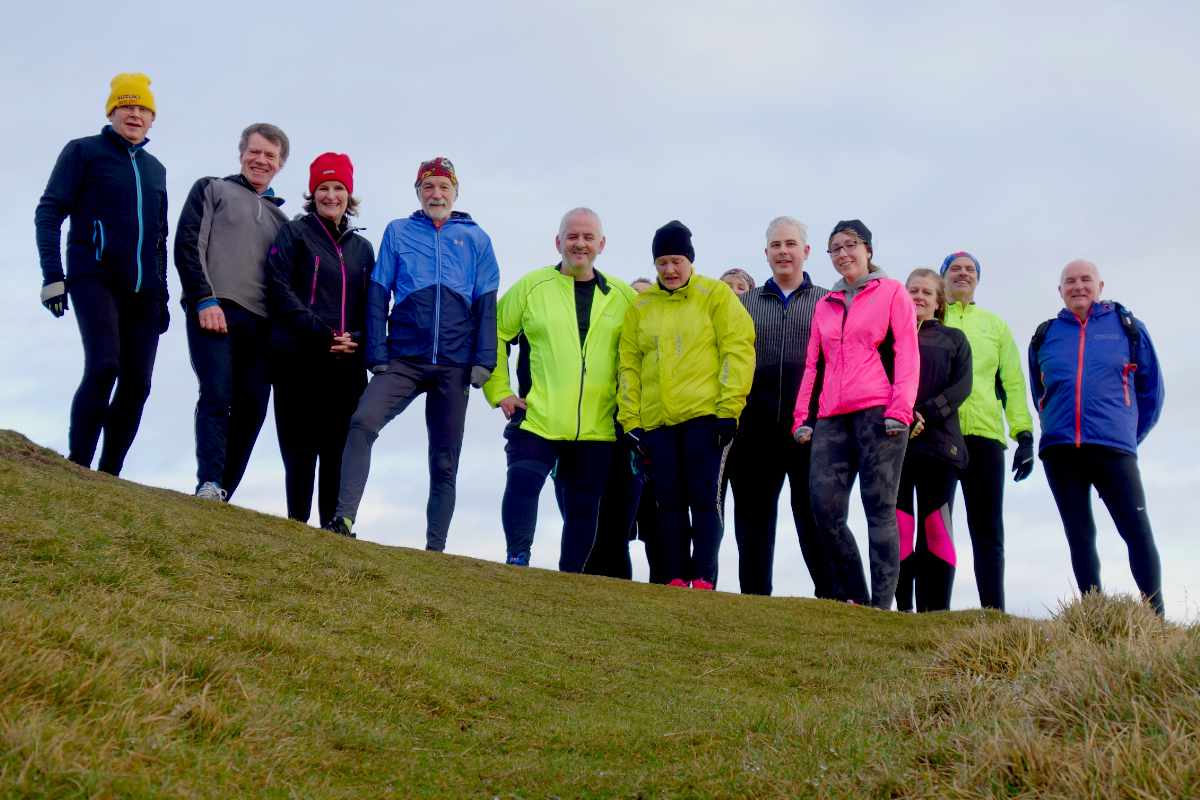 photo of a group of runners set against the sky.