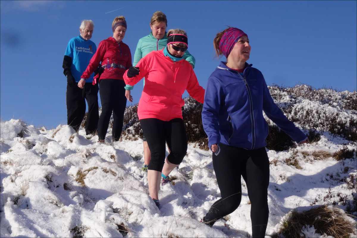 photo of a group of runners making their way through deep snow.