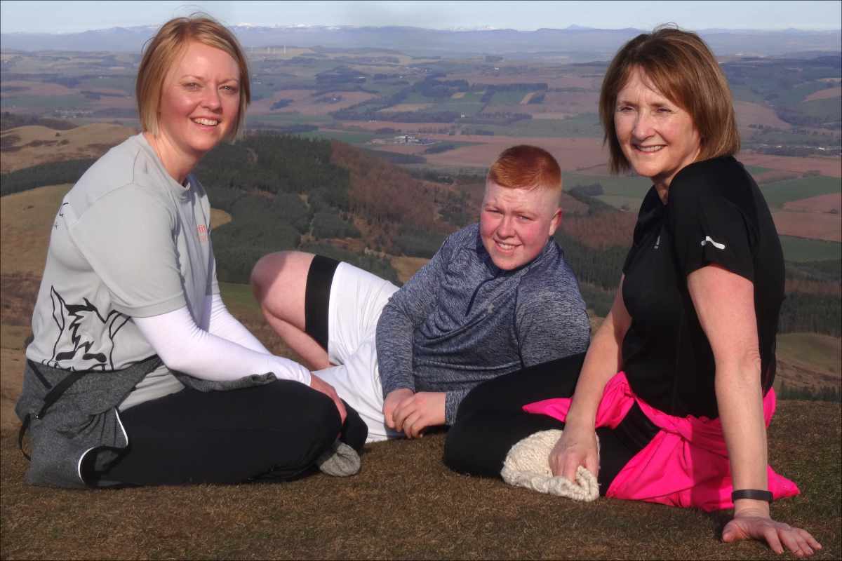 photo of three generations of the same family resting at the top of a hill.