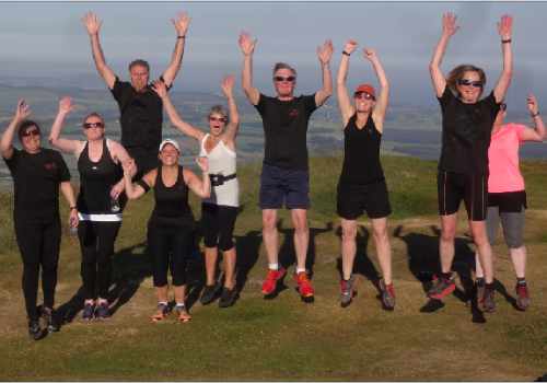 photo of a group of Couch to 5K graduates jumping up and raising their arms to the sky.