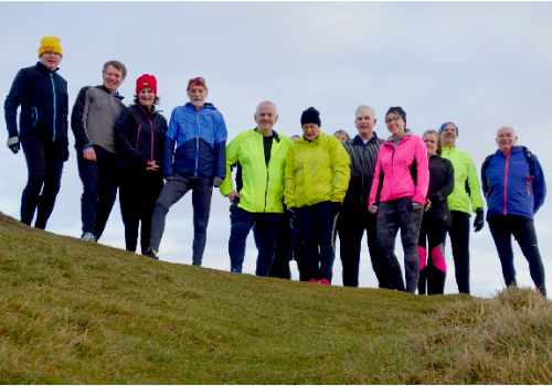 photo of a group of runners set against the sky.