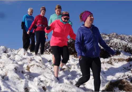 photo of a group of runners making their way through deep snow.