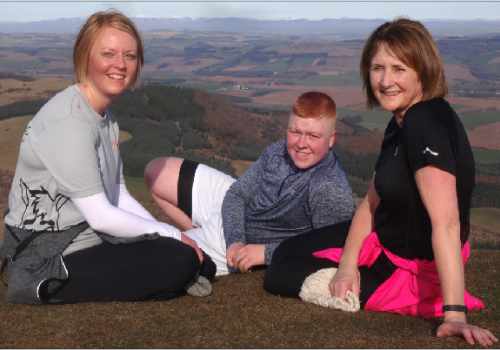 photo of three generations of the same family resting at the top of a hill.